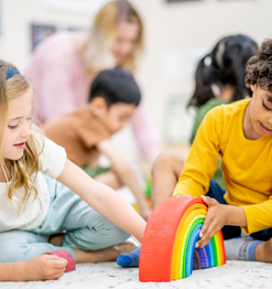 what does my kindergartener need to know before kindergarten ; young kid playing with rainbow toy